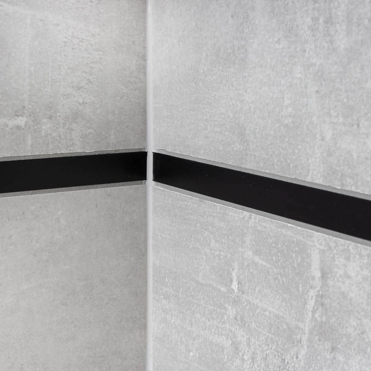 Lifestyle image of the decorative profile aluminium black installed between light-coloured tiles