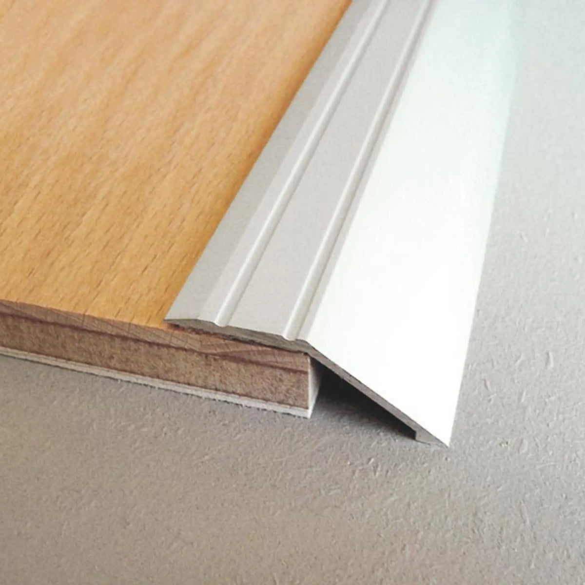 Lifestyle image ramp profile aluminium silver with ribbed surface creating transition to parquet